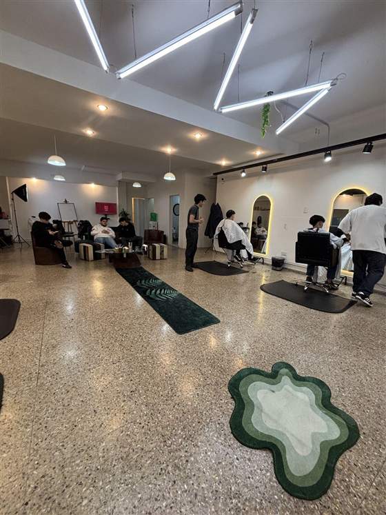 Interior del salón LMG Estilismo con clientes en la sala de espera y estilistas trabajando.